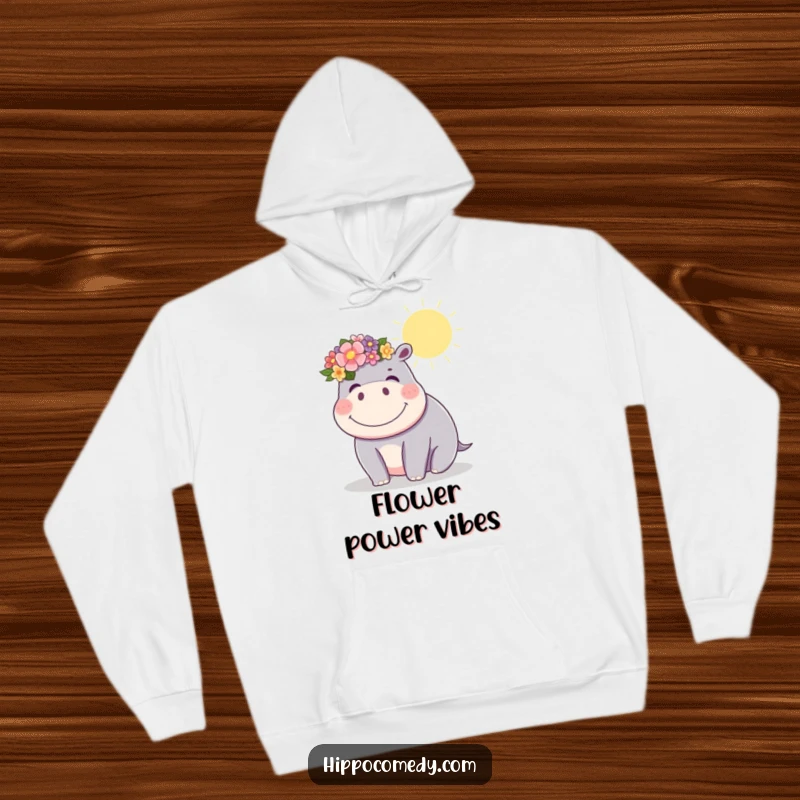Funny kawaii hippopotamus wearing a flower crown, giggling brightly in the sun, featured on a cozy hoodie for funny gifting.